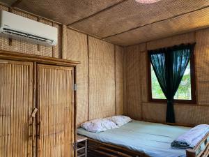 Kleines Zimmer mit einem Bett und einem Fenster in der Unterkunft Farmstay Ao Nhà 