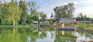 ein Teich mit einem Haus in der Mitte in der Unterkunft Farmstay Ao Nhà 