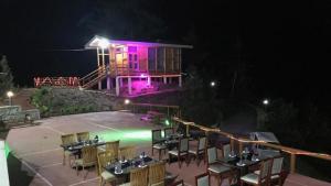 um restaurante com iluminação roxa em frente a uma casa em Zhingkham Cottages em Thimphu