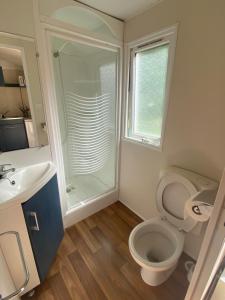 a bathroom with a shower and a toilet and a sink at Camping Val Saint Jean in Mauriac
