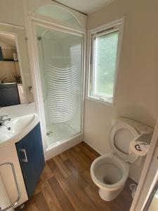 ein Bad mit einer Dusche, einem WC und einem Waschbecken in der Unterkunft Camping Val Saint Jean in Mauriac