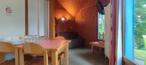 a dining room with a wooden table and chairs at Camping Val Saint Jean in Mauriac