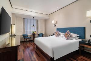 上海市にあるSSAW ブティック ホテル 上海 外灘の白い大型ベッドとテーブルが備わるホテルルームです。