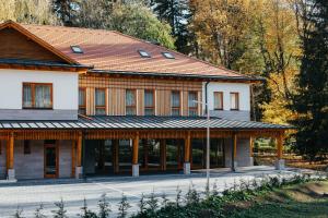 un grand bâtiment en bois avec un toit rouge dans l'établissement Villa Bellini Borszék, à Borsec