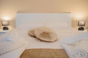 Una cama blanca con dos almohadas encima. en Esclusivo Loft Centro Storico private garden E-Bike, en Cherasco