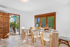 a dining room with a table and white chairs at Villa K9 Ortenbach in Ifach