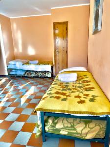 a room with two beds and a checkered floor at Rifugio Tra Le Vette in Bardonecchia