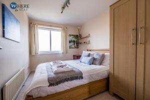 um quarto com uma cama grande e uma janela em Warm 3 bed Apartment Aberdeen em Aberdeen