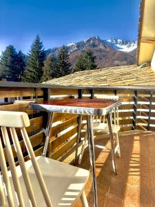 a table and chairs on a balcony with a view of a mountain at Rifugio Tra Le Vette in Bardonecchia