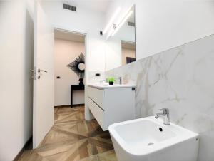 a white bathroom with a sink and a mirror at Trieste Stazione - Suite & WiFi in Trieste