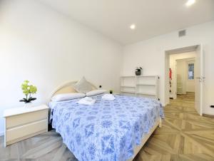 a white bedroom with a bed with a blue blanket at Trieste Stazione - Suite & WiFi in Trieste