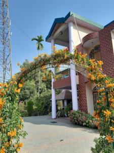 einem Bogen mit Blumen vor einem Gebäude in der Unterkunft Bononi Guest House Jorhat in Jorhat