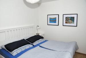 Una cama en un dormitorio con dos cuadros en la pared. en Landhaus Gericke, en Kappeln