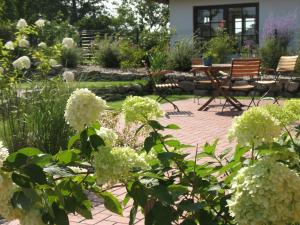 un jardín con mesa, sillas y flores en Landhaus Gericke, en Kappeln