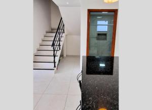 a hallway of a house with stairs and a door at Casa do Sol - Nova Guarapari in Guarapari
