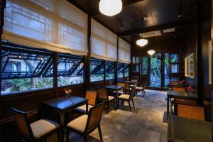 a restaurant with tables and chairs and windows at Jiangnan House Changyuan in Suzhou