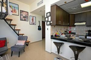 uma cozinha com um balcão e algumas cadeiras num quarto em Melody Studio Apartment Al reem. em Abu Dhabi
