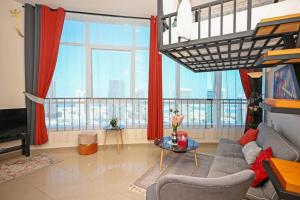 uma sala de estar com um sofá e uma grande janela em Melody Studio Apartment Al reem. em Abu Dhabi