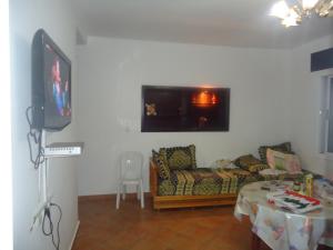 ein Wohnzimmer mit einem Sofa und einem TV in der Unterkunft Appartement CORNICHE vue sur MER in Martil