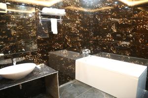 a bathroom with a sink and a bath tub at MK Regency in Greater Noida