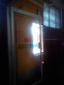Bapu Guest House,Bhubaneswar في بوهفانيشفار: باب مع علامة على جانب المبنى