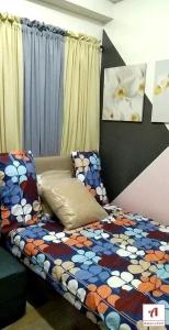 a bedroom with a bed with a colorful comforter at Amaze365 Holiday Homes Condotel at Trees Residence Fairview in Manila