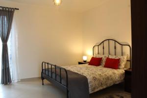 um quarto com uma cama com duas almofadas vermelhas em Il Bumbunin em Moncucco Torinese