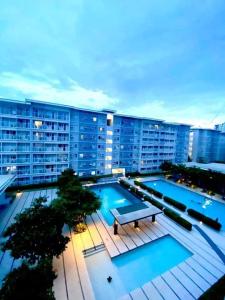 un gran edificio de apartamentos con piscina y mesa en Amaze365 Holiday Homes Condotel at Trees Residence Fairview en Manila