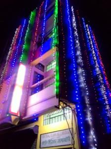 Sewak Lodge Silchar في سيلكار: مبنى به أضواء ملونة في الليل