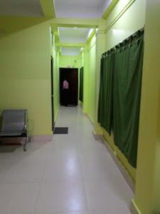un pasillo vacío con una cortina verde y una puerta en Sewak Lodge Silchar, en Silchar