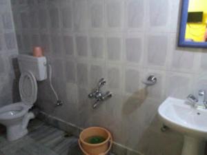 Sewak Lodge Silchar في سيلكار: حمام مع مرحاض ومغسلة