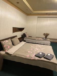 Відпочинковий комплекс,міні готель Старий дворик في إلفيف: غرفة نوم بسريرين عليها مناشف