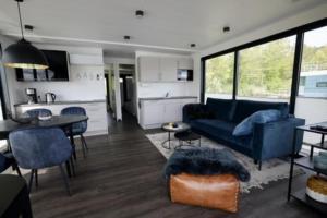 a living room with a blue couch and a kitchen at Hausboot freiZeit - LP1 in Höxter