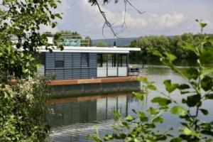 a house on a dock on a body of water at Hausboot freiZeit - LP1 in Höxter