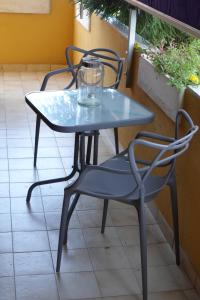 una mesa de cristal y sillas en un patio en Ben House, en Santa Giusta
