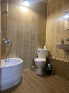 ein Badezimmer mit einer Badewanne, einem WC und einem Waschbecken in der Unterkunft Відпочинковий комплекс,міні готель Старий дворик in Lwiw