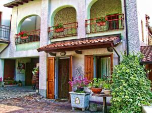 a building with potted plants and balconies on it at B&B Curtif in Tavernola Bergamasca