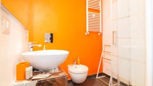 Un baño con un lavabo blanco y un inodoro. en Ben House, en Santa Giusta