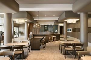 a restaurant with tables and chairs and a bar at SpringHill Suites Ewing Township Princeton South in Ewing