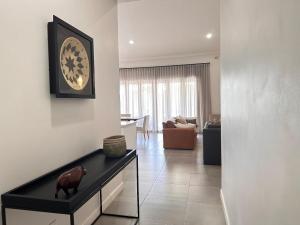 a living room with a clock on the wall at Narina Villa in Victoria Falls