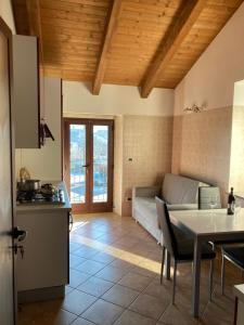 uma cozinha e sala de estar com uma mesa e um sofá em La casa del Picchio em Vico Canavese