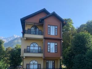 a tall building with a balcony on top of it at The Sojourn in Dharamshala