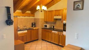 ヴェゾナにあるRoyal 141 SKI LIFT & TERRACE apartment 8 pers by Alpvision Résidencesのキッチン(木製キャビネット、シャンデリア付)