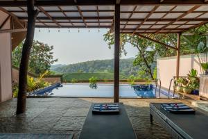 a patio with a table and a view of a pool at Simroseate in Agonda