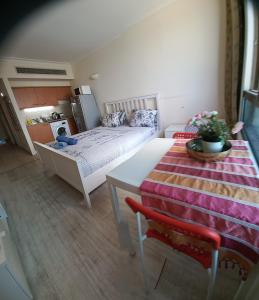 Zimmer mit einem Bett und einem Tisch sowie einer Küche in der Unterkunft Stunning Studio on The Water in Haifa