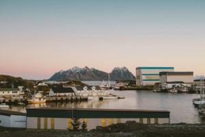 a marina with boats in the water with mountains at Leilighet i nybygg in Svolvær