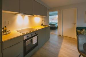 a kitchen with a sink and a stove top oven at Leilighet i nybygg in Svolvær