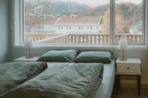 a bedroom with two beds and a large window at Leilighet i nybygg in Svolvær