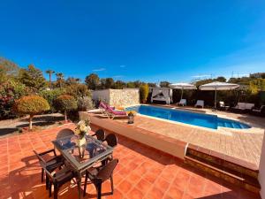 un patio con mesa y sillas junto a una piscina en Sebastian's House, en Coín