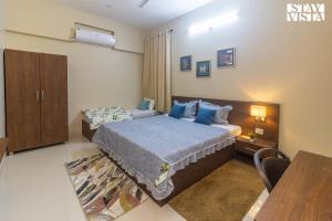 Un dormitorio con una cama, un escritorio y una mesa. en StayVista's Villa Orchid - 8 min away from Mahakaleshwar, en Ujjain